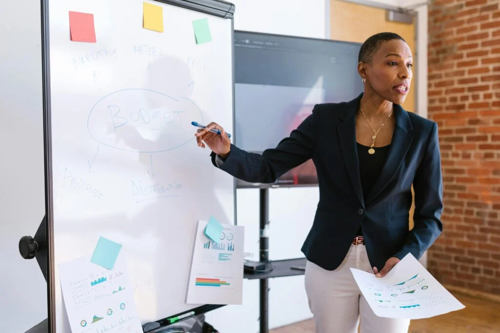Professional business analyst presenting data analytics and reporting insights on whiteboard