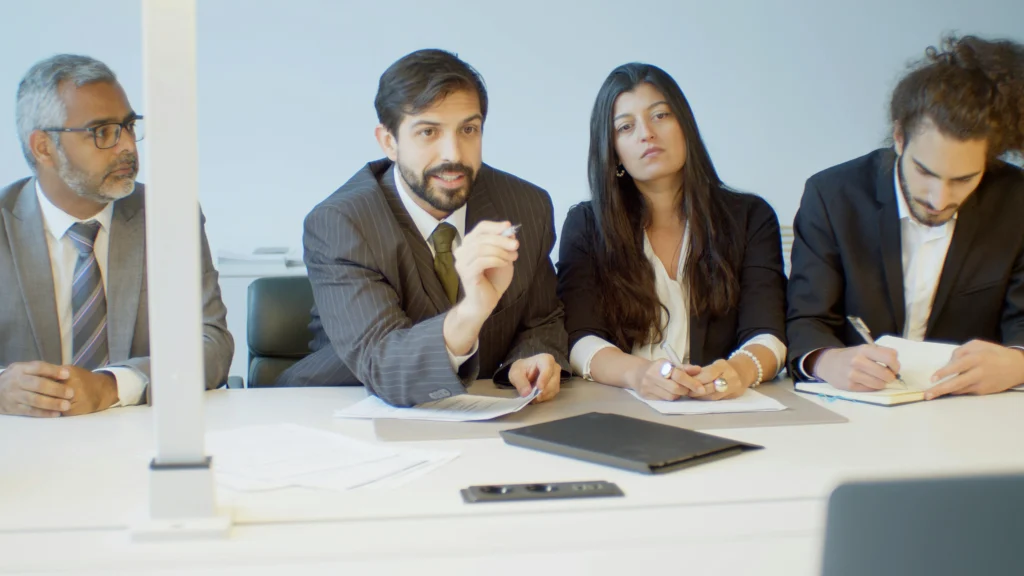 Professional financial consulting team discussing forecasting and budget planning in boardroom meeting