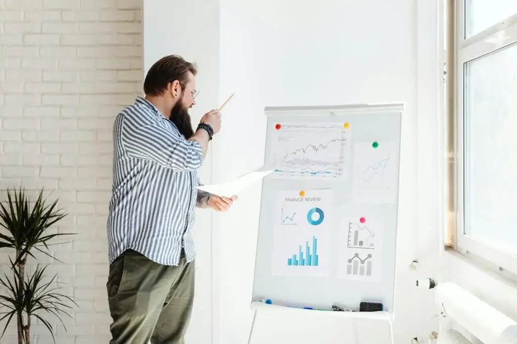 Pearl Lemon Consulting Canada growth planning strategist analyzing competitive strategy charts and financial data on whiteboard in modern office