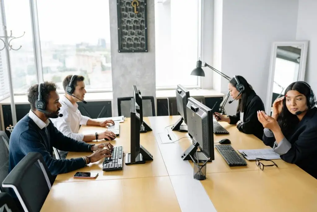 Diverse team of sustainability consultants collaborating with headsets in modern office