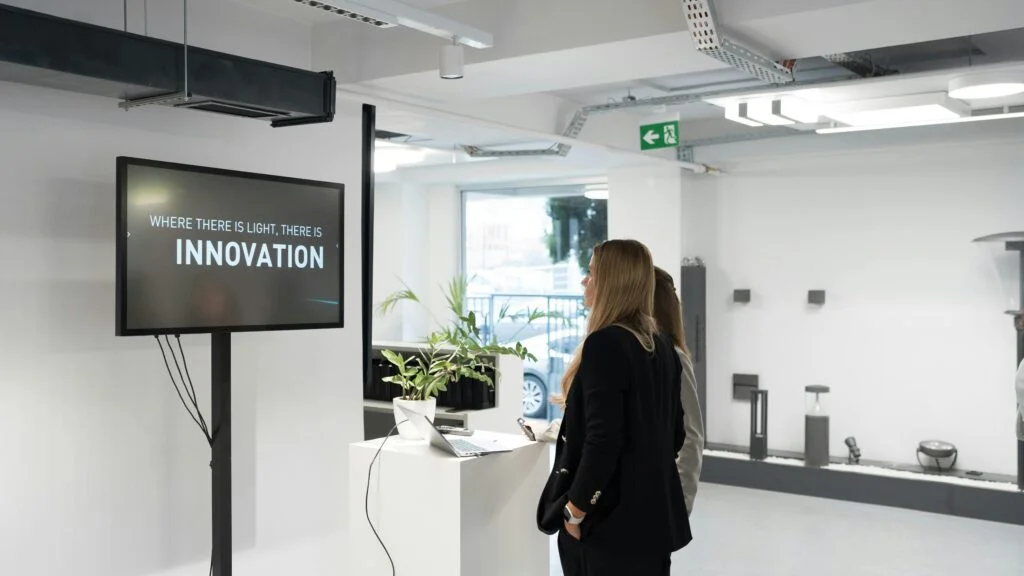 Professional businesswoman viewing innovation presentation screen in modern office during technical talent acquisition consulting session