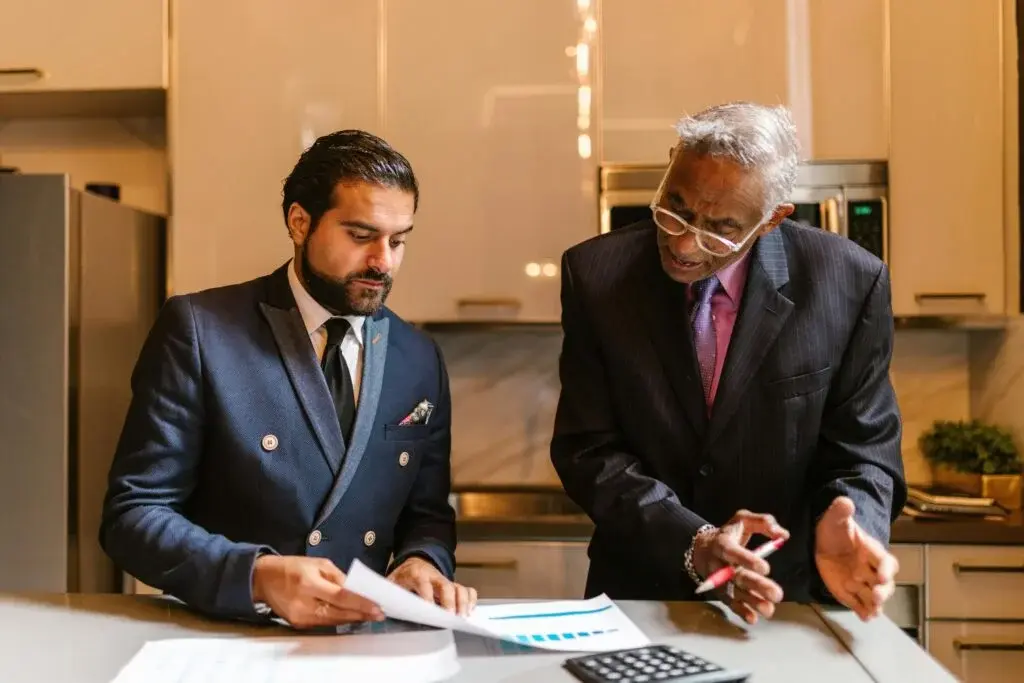 Two business professionals reviewing financial documents and charts during consulting session in Canada