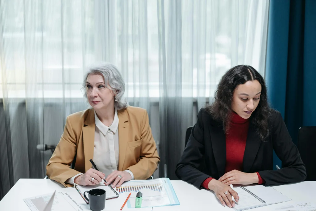 Professional female consultants reviewing business strategy documents and performance charts in modern boardroom