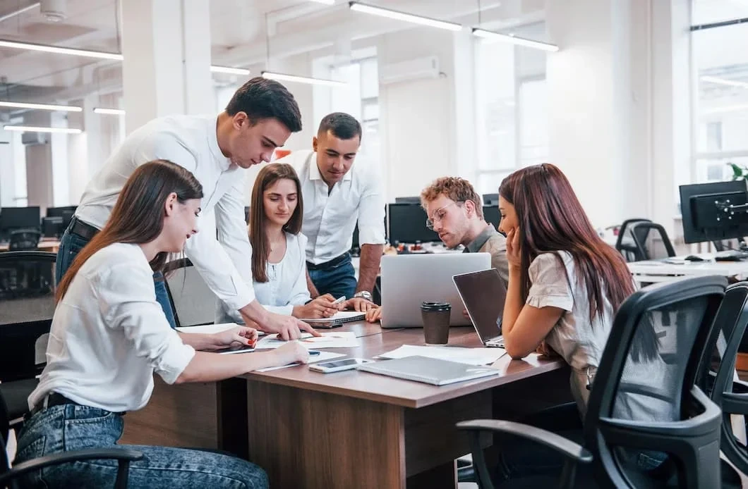 Team reviewing documents and laptop in office